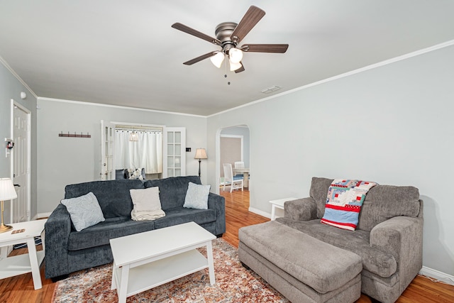 living room featuring light hardwood / wood-style floors, ceiling fan, and ornamental molding