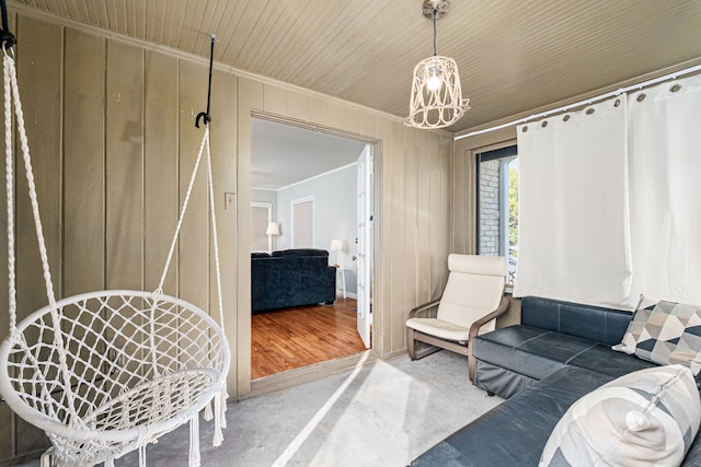 interior space featuring wooden walls, crown molding, and concrete floors