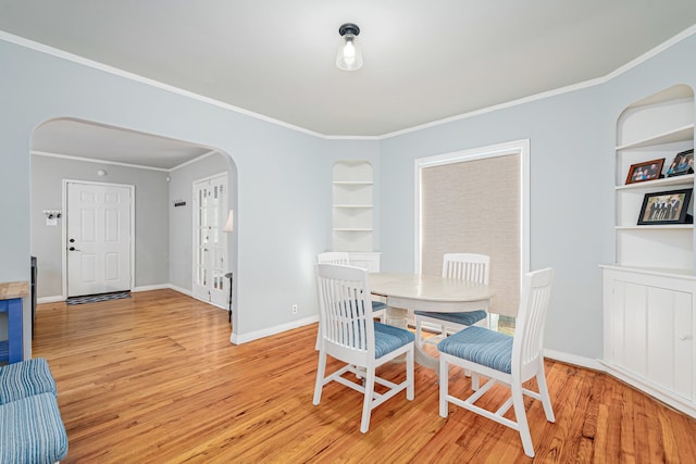 dining room with crown molding and light hardwood / wood-style flooring