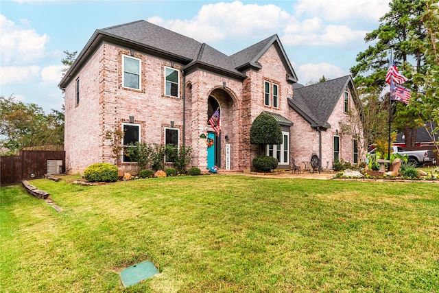 view of front facade featuring a patio, a front yard, and central AC