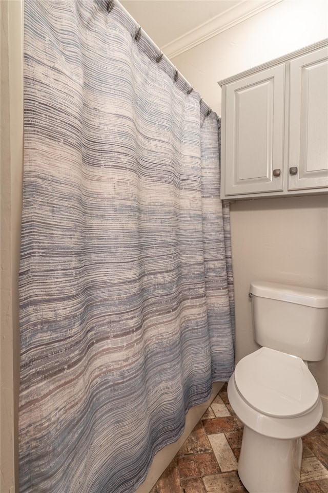 bathroom featuring ornamental molding, toilet, and a shower with curtain