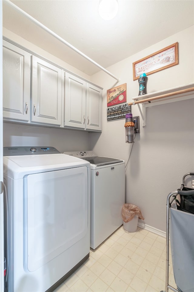 washroom with cabinets and washer and dryer