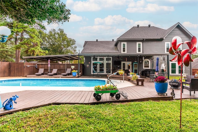 view of pool featuring a lawn and a wooden deck