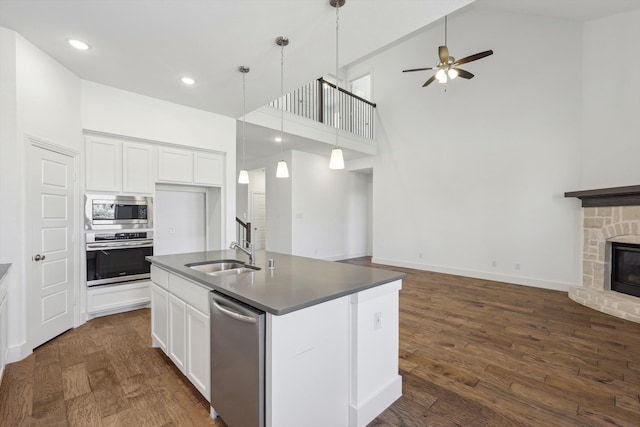 kitchen with a kitchen island with sink, high vaulted ceiling, white cabinets, sink, and stainless steel appliances