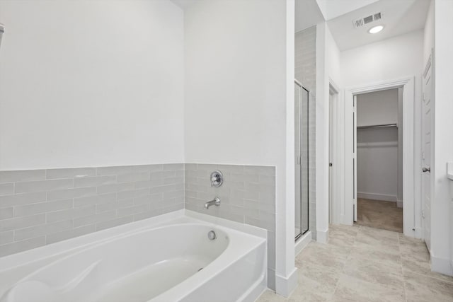 bathroom featuring tile patterned flooring and shower with separate bathtub