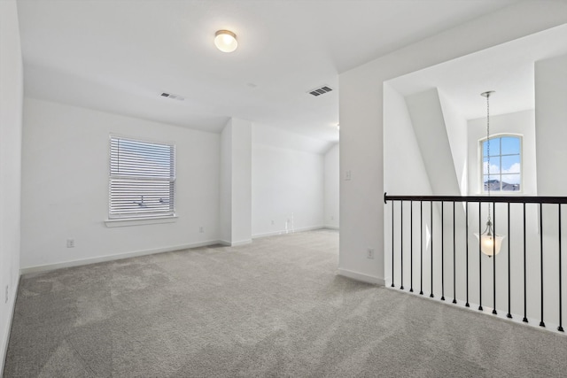 carpeted empty room with lofted ceiling