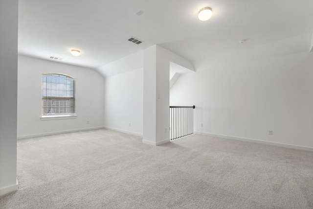 additional living space with light carpet and vaulted ceiling