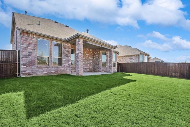 back of house with a lawn and a patio