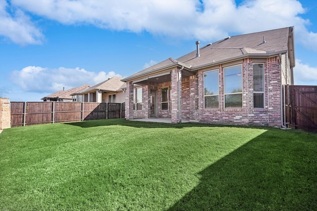 back of house with a lawn and a patio area