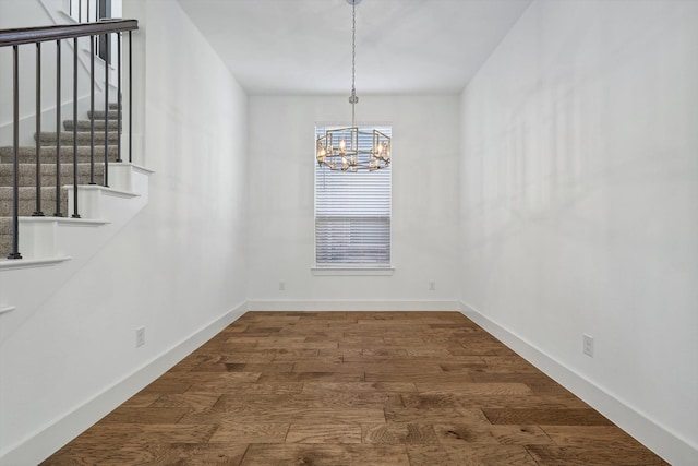 unfurnished dining area with dark wood-type flooring and a chandelier