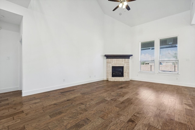 unfurnished living room with a fireplace, ceiling fan, and dark hardwood / wood-style flooring