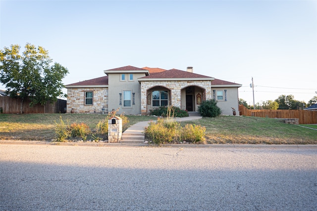 mediterranean / spanish house with a front yard