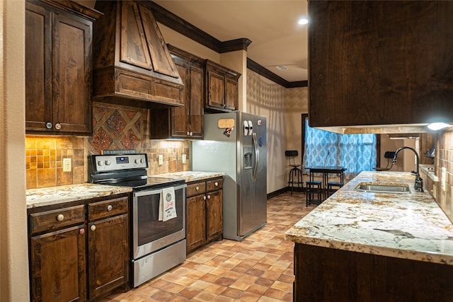 kitchen with stainless steel appliances, dark brown cabinetry, sink, ornamental molding, and premium range hood