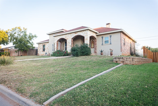 mediterranean / spanish house featuring a front lawn