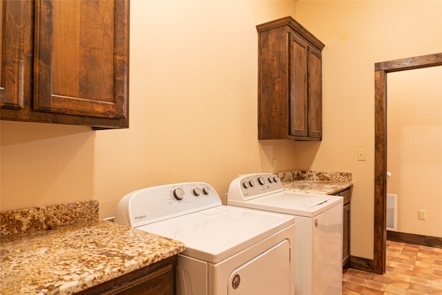 clothes washing area with cabinets and independent washer and dryer