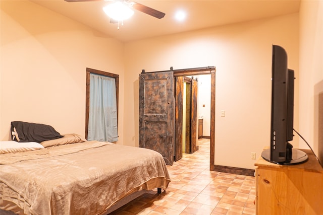 bedroom featuring a barn door and ceiling fan