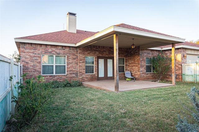 rear view of property featuring a lawn and a patio