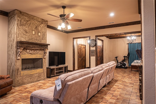 living room featuring ornamental molding, ceiling fan with notable chandelier, and a fireplace