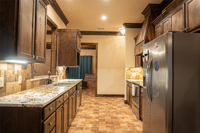 kitchen featuring light stone counters, crown molding, appliances with stainless steel finishes, decorative backsplash, and sink