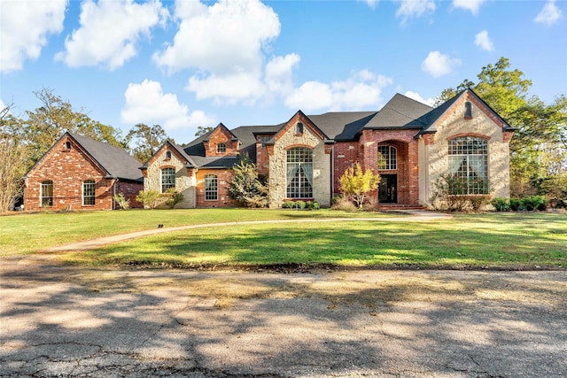 french country style house featuring a front yard