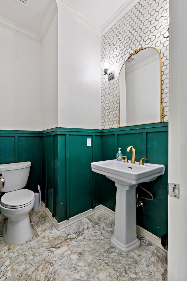 bathroom featuring toilet and crown molding