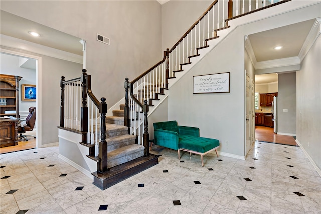 stairs with a towering ceiling and ornamental molding