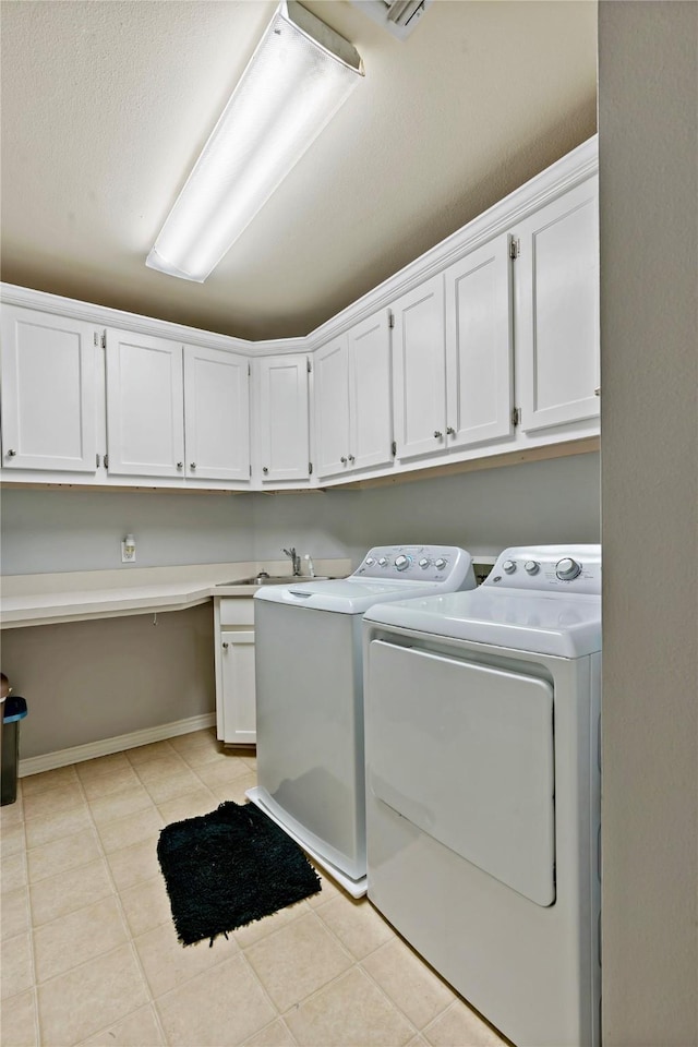 laundry area featuring cabinets, washing machine and dryer, sink, and light tile patterned flooring