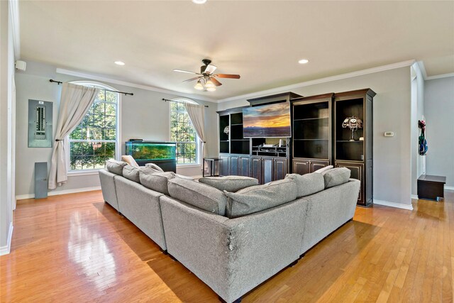 living room featuring ornamental molding, light wood-type flooring, and ceiling fan