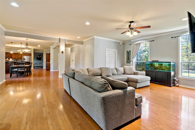 living room with crown molding, plenty of natural light, and light hardwood / wood-style flooring