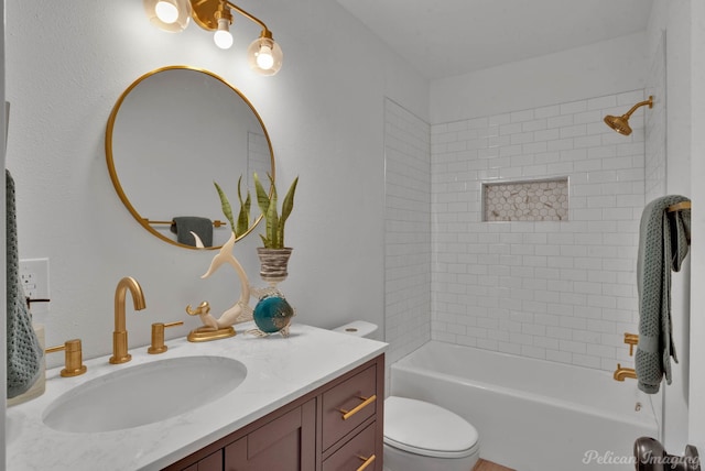 full bathroom with vanity, tiled shower / bath combo, and toilet