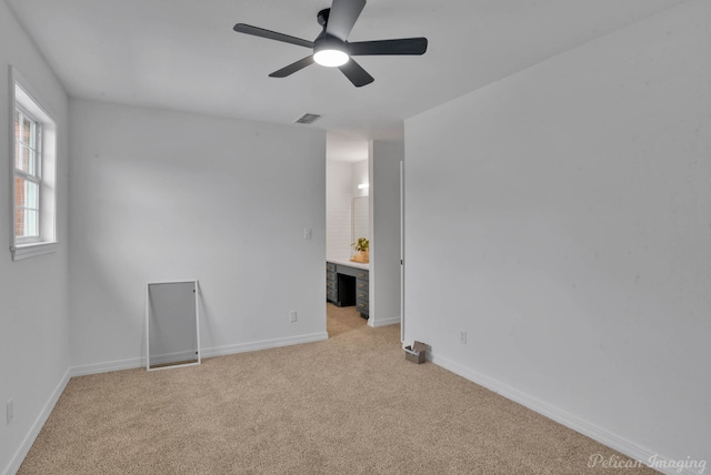 carpeted spare room featuring ceiling fan