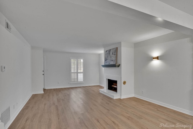 unfurnished living room with a fireplace and light hardwood / wood-style flooring