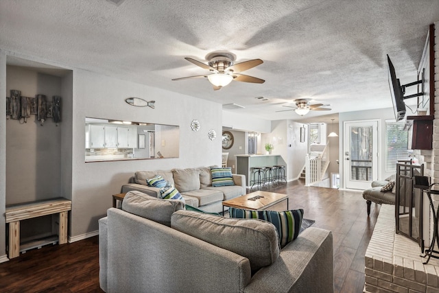 living room featuring ceiling fan, a textured ceiling, and dark hardwood / wood-style flooring