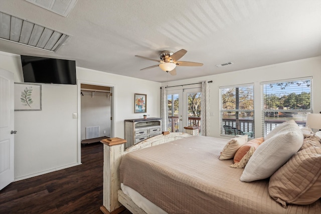 bedroom with access to outside, dark hardwood / wood-style flooring, ceiling fan, a closet, and a walk in closet