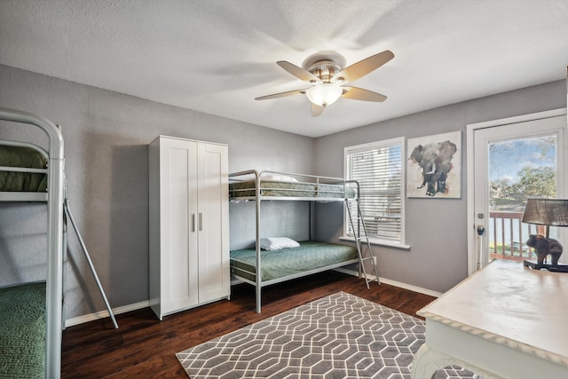 bedroom featuring multiple windows, access to outside, ceiling fan, and dark hardwood / wood-style floors