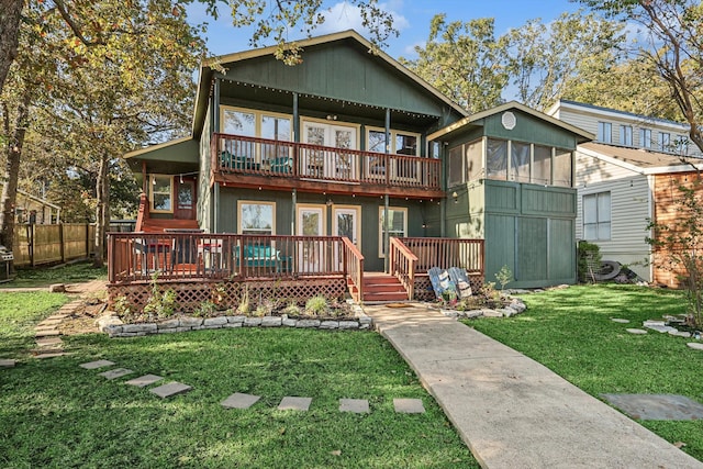 view of front of house with a balcony, a front yard, and a wooden deck