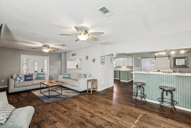 living room featuring a textured ceiling, dark hardwood / wood-style flooring, and ceiling fan