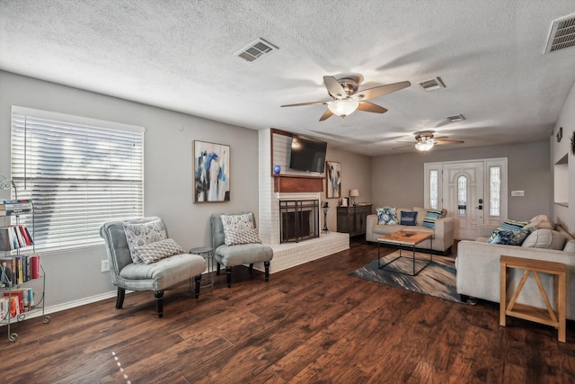 living room with dark hardwood / wood-style floors, plenty of natural light, and a textured ceiling