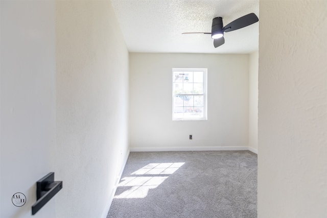 spare room with light colored carpet, a textured ceiling, and ceiling fan