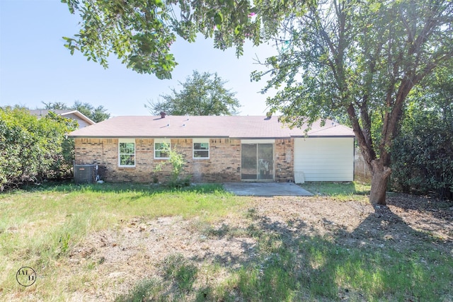 2318 May Ln, Grand Prairie, TX 75050 - back of property featuring brick siding, a patio, cooling unit, and a lawn