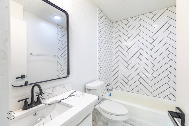 full bathroom with toilet, tiled shower / bath combo, vanity, and a textured ceiling