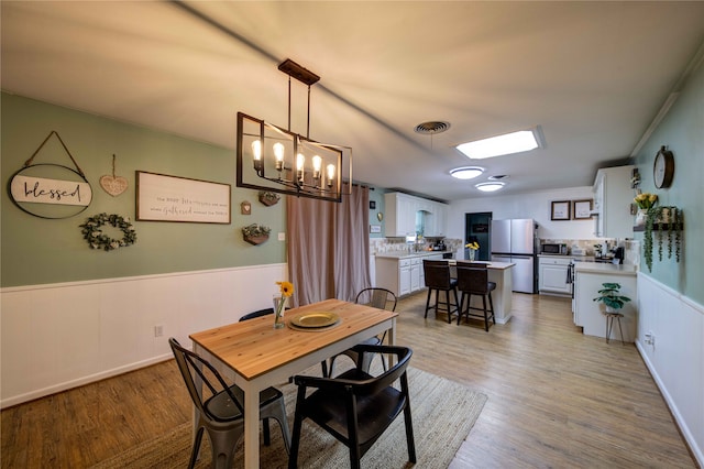 dining room with an inviting chandelier and light wood-type flooring