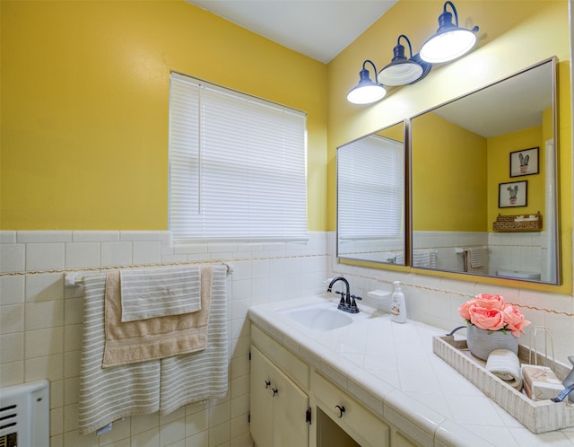 bathroom featuring vanity and tile walls