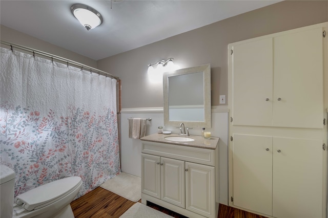 bathroom featuring toilet, vanity, hardwood / wood-style floors, and walk in shower