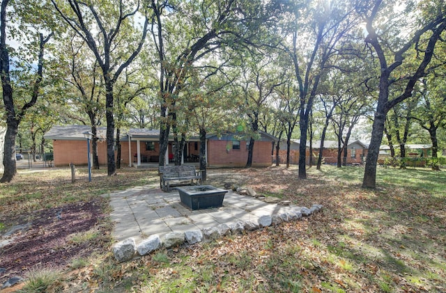 view of yard featuring an outdoor fire pit and a patio area