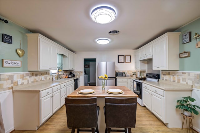 kitchen featuring white cabinetry, light hardwood / wood-style flooring, appliances with stainless steel finishes, and a center island