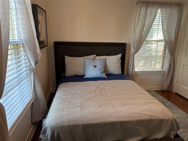 bedroom with wood-type flooring and multiple windows