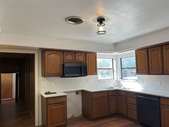 kitchen featuring dark wood-type flooring, a textured ceiling, sink, and black appliances