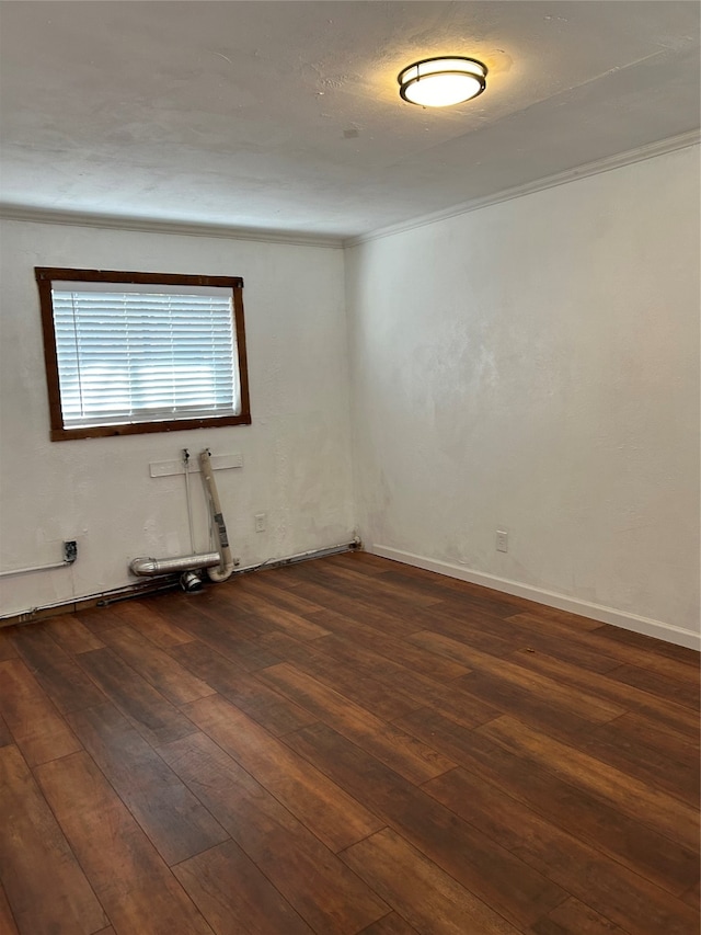 empty room featuring ornamental molding and dark hardwood / wood-style floors