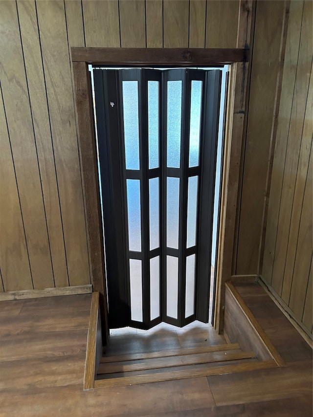 entryway featuring wood walls and dark wood-type flooring